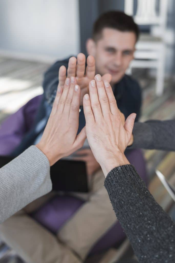 groupe de personnes assises qui se tapent dans les mains pour soutien
